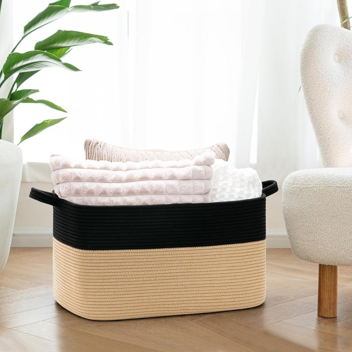 Woven cotton rope basket holding folded blankets and towels