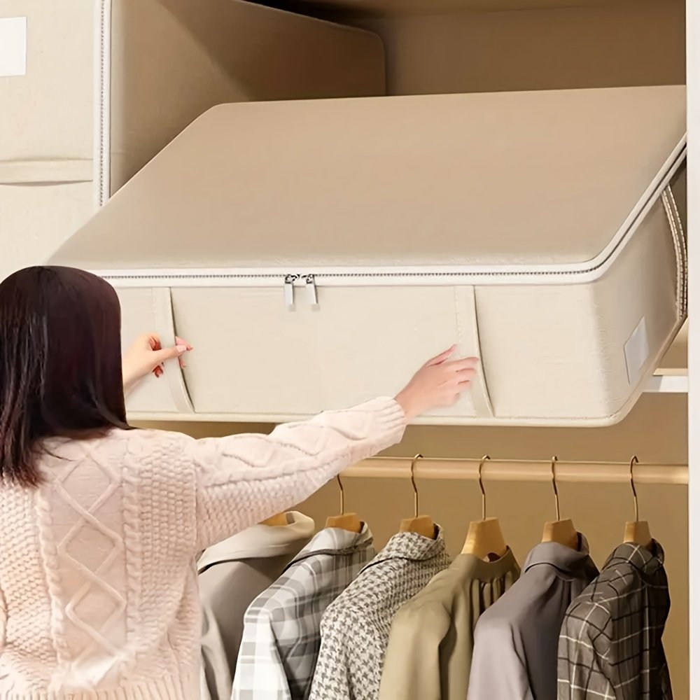 Oatmeal fabric storage box holding folded clothes under bed
