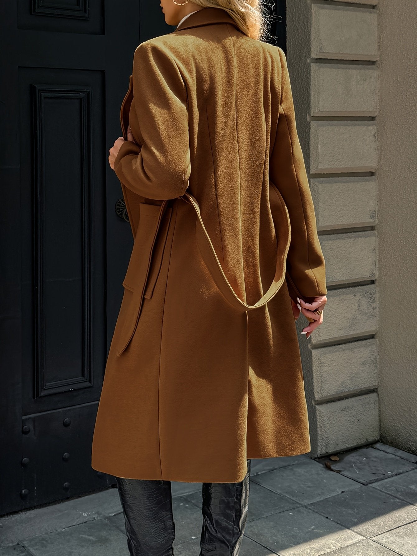 Side view of the long cut on the women's camel coat