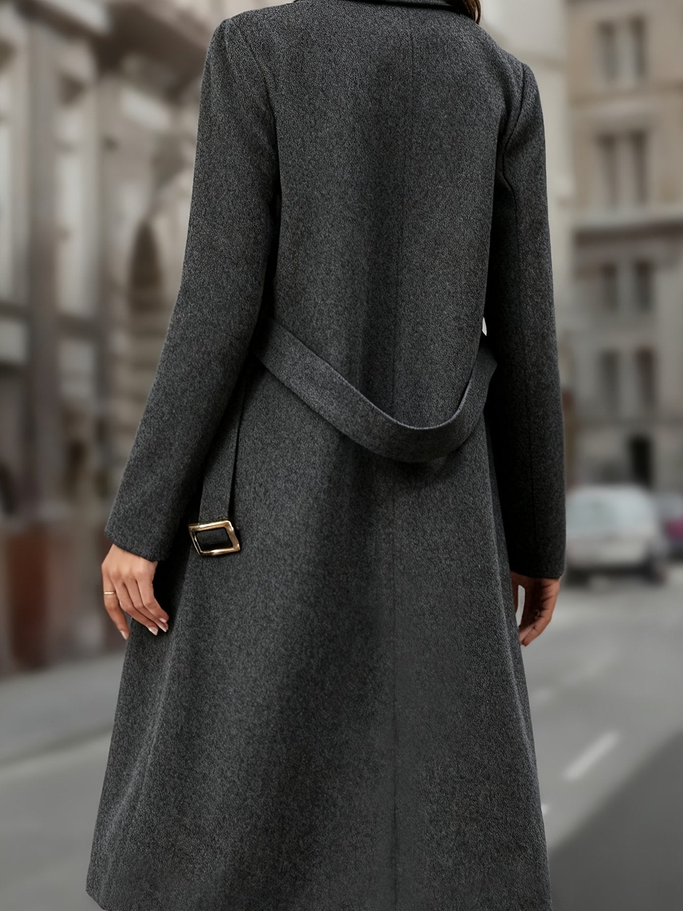 Women's long trench coat worn with hands in the side pockets, smart office styling